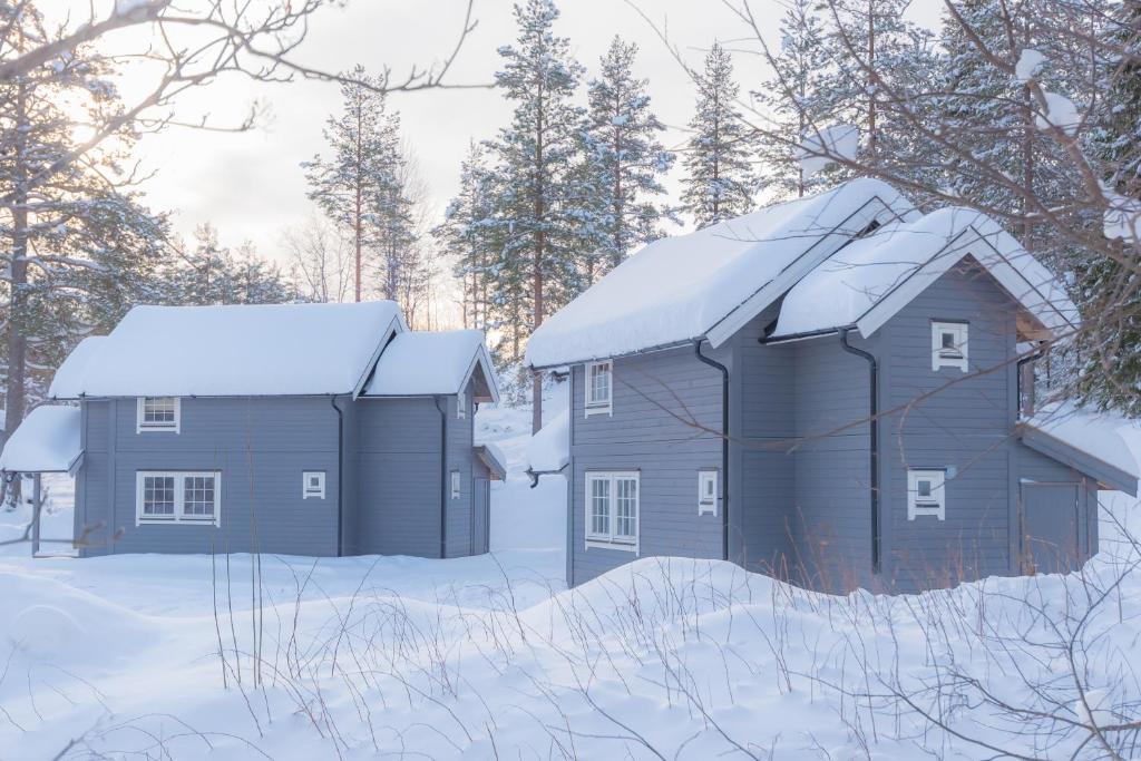 Deux maisons dans la neige avec des arbres en arrière-plan dans l'établissement Fjelltun 6-sengs, à Trysil