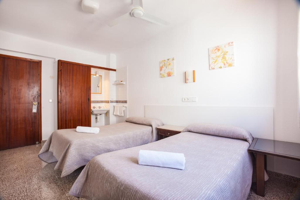 una camera d'albergo con due letti e un bagno di Hostal Las Nieves a Ibiza Città