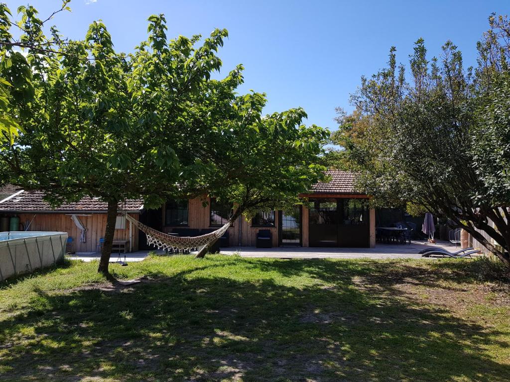 a house with a hammock in a yard at Maison Claouey in Lège-Cap-Ferret