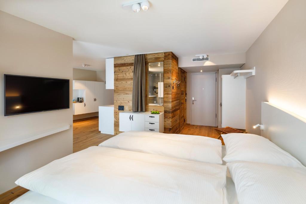 a hotel room with two beds and a television at Hotel Allegra Lodge in Kloten