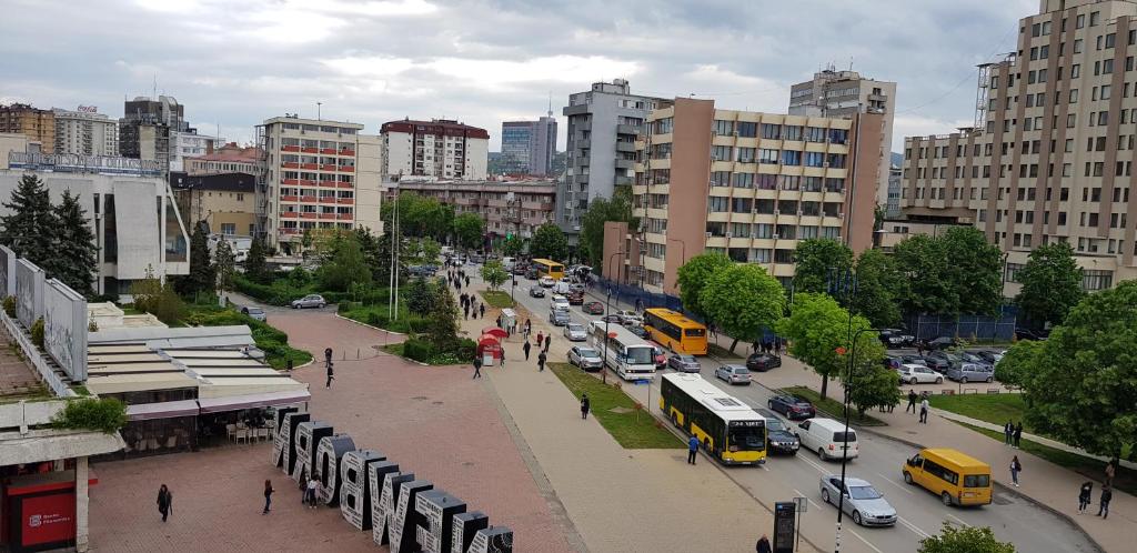 a busy city street with cars and buses at Pristina Downtown Apartment in Prishtinë