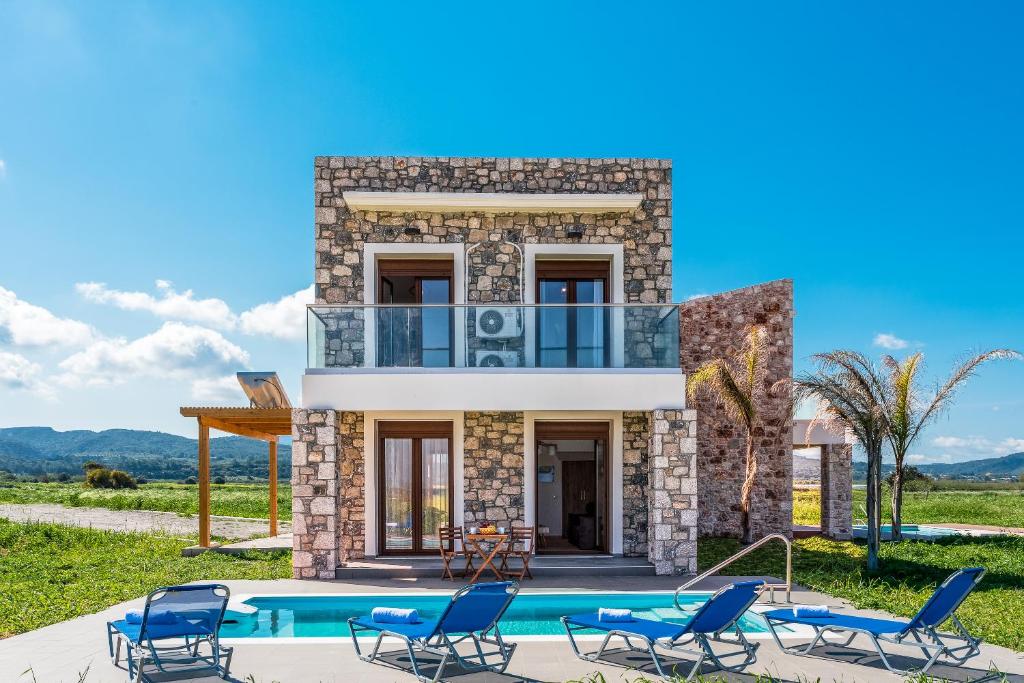 a villa with a swimming pool and chairs at Diagoras & Attalos Villas in Phanaes