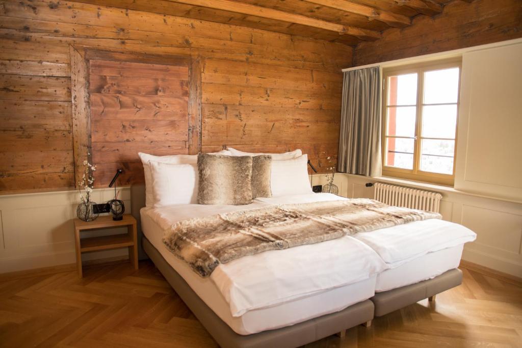 a bedroom with wooden walls and a large bed at Hotel Restaurant Falkenburg in St. Gallen
