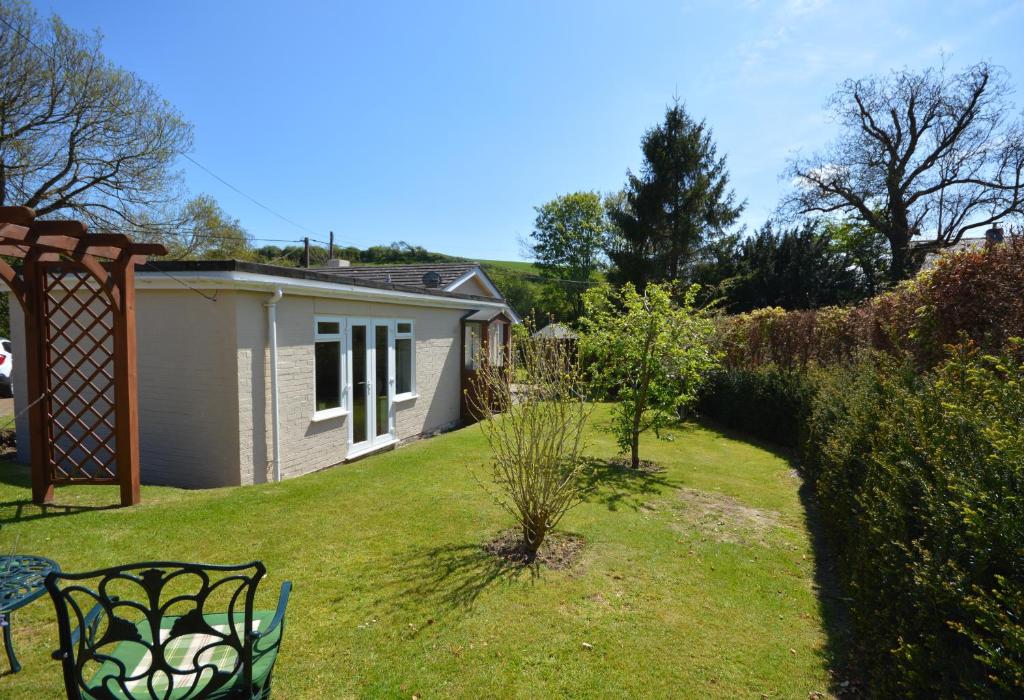 a garden with a house and a bench in a yard at The Willows in Rookley