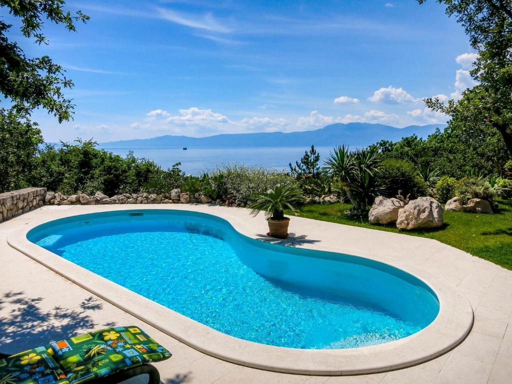 a swimming pool in a backyard with a view of the ocean at Villa Anamia by Interhome in Kostrena