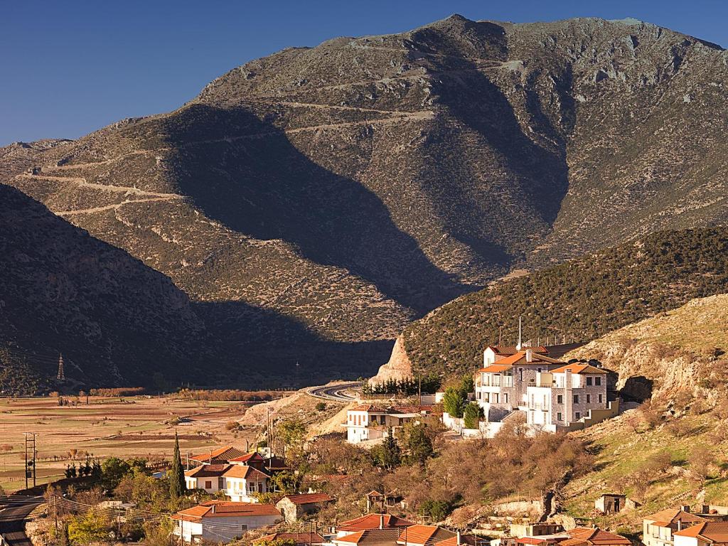 a village on a hill with a mountain in the background at Hondos Classic Hotel & Spa in Nestáni