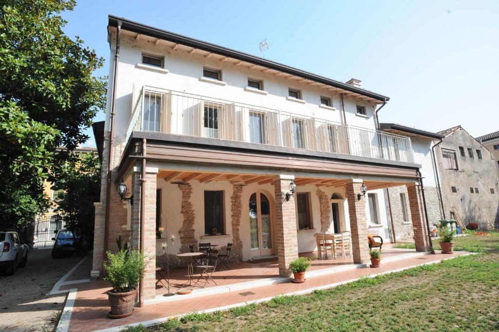 uma grande casa branca com um pátio em frente em Il Giardino Del Conte Custoza em Marmirolo