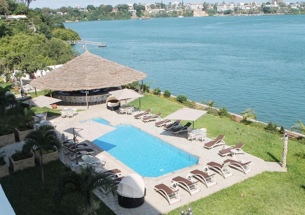 uma vista superior para uma piscina com cadeiras e guarda-sóis em CityBlue Creekside Hotel & Suites em Mombasa