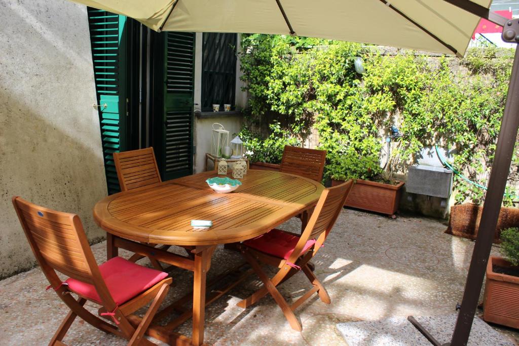 una mesa de madera y sillas con sombrilla en La Badia 11, en Cava deʼ Tirreni