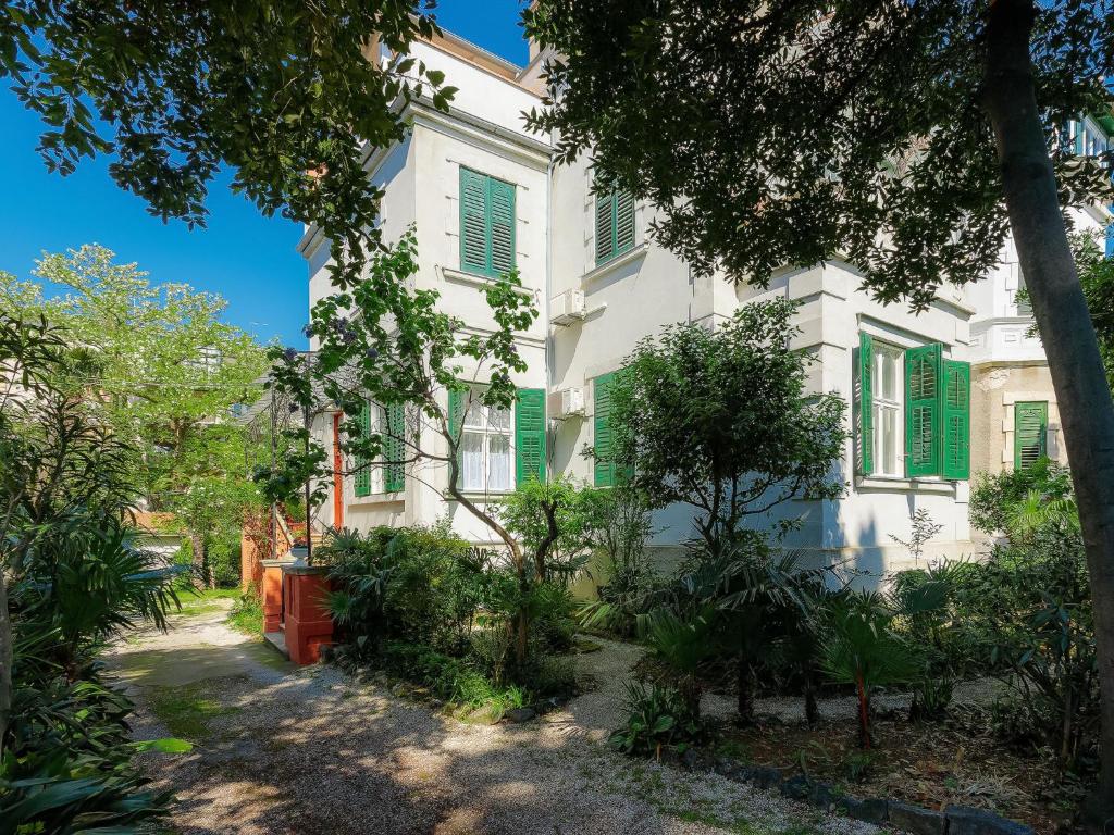 an old white house with green shutters at Apartment Silvia by Interhome in Pula