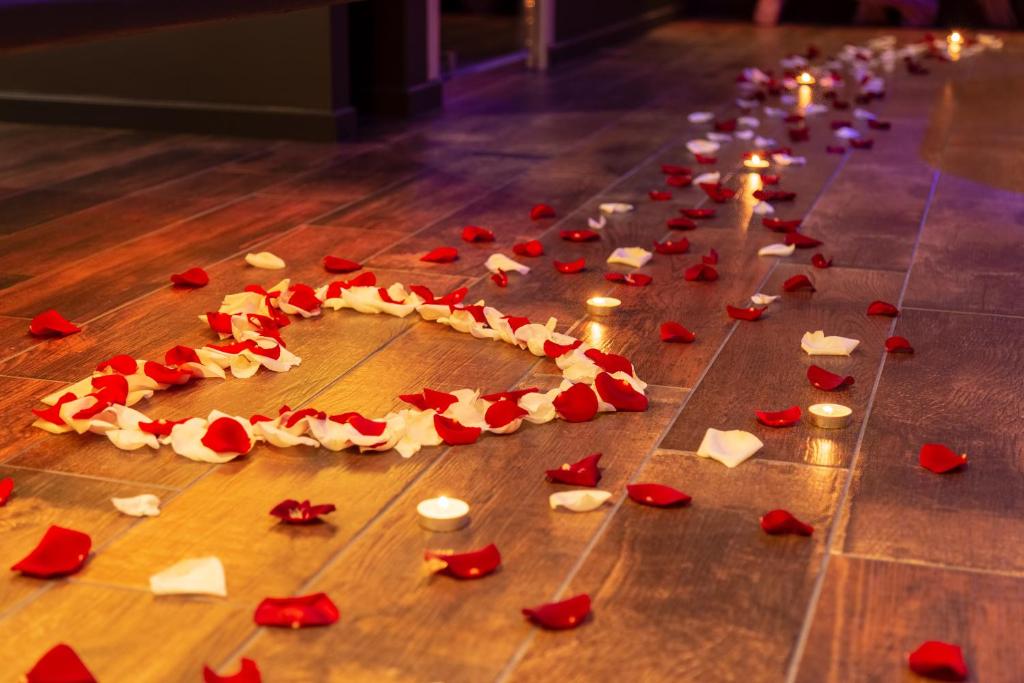 Une bande de roses rouges sur le sol avec des bougies dans l'établissement L'effet SPA, à Corbehem