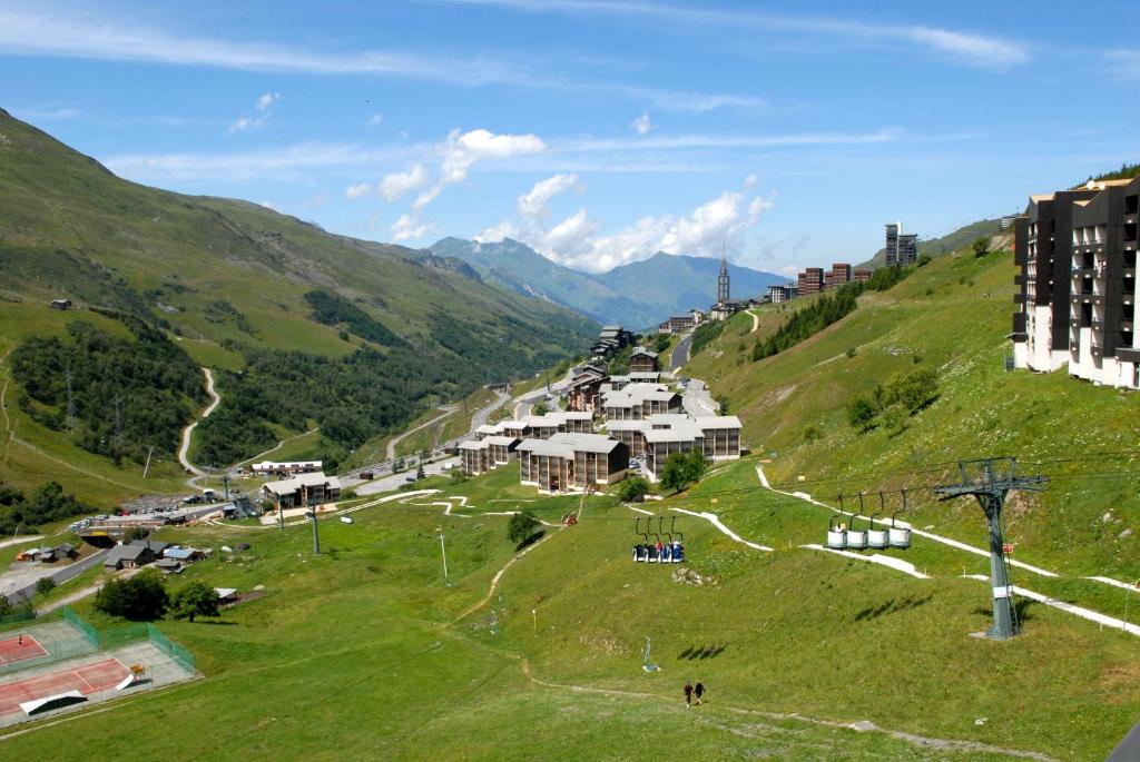 a green hill with a village on it at Résidence Azureva Les Menuires in Les Menuires
