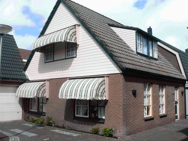 una casa de ladrillo rojo con techo de gambrel en Westenwind, en Egmond aan Zee