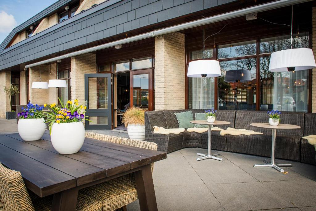 デ・コーフにあるHotel Boschrandの花のテーブル付きのパティオ