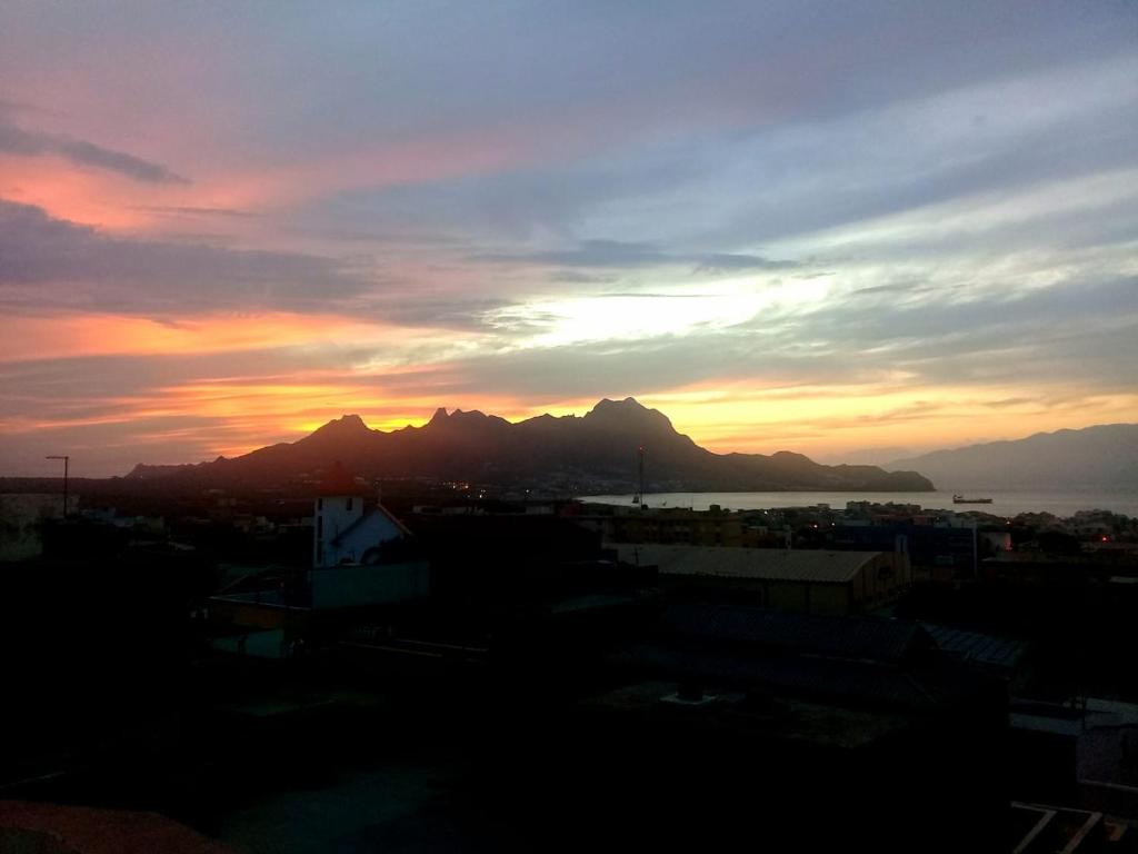 a sunset over a city with a mountain in the background at Residencial Casa da Luz in Mindelo