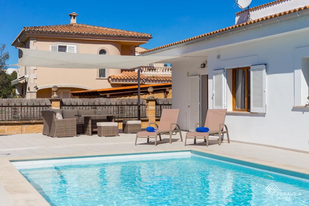 a villa with a swimming pool and a house at Berganti in Port d'Alcudia