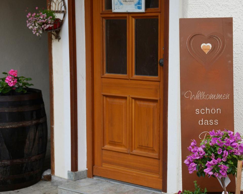 a wooden door with a sign next to a barrel at Landhof Lydia in Roggendorf