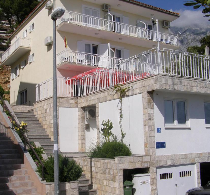 a building with a balcony on top of it at Apartments Šarić in Baška Voda