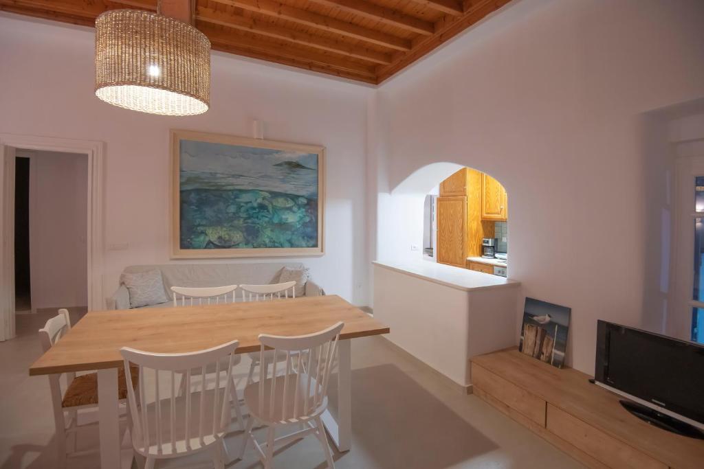 a kitchen and dining room with a table and chairs at M Residence Little Venice in Mikonos