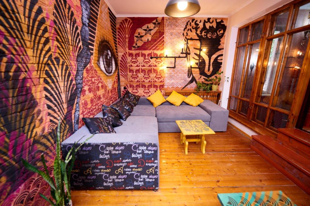a living room with a couch and a wall covered in graffiti at Wanderlust Hostel in Almaty