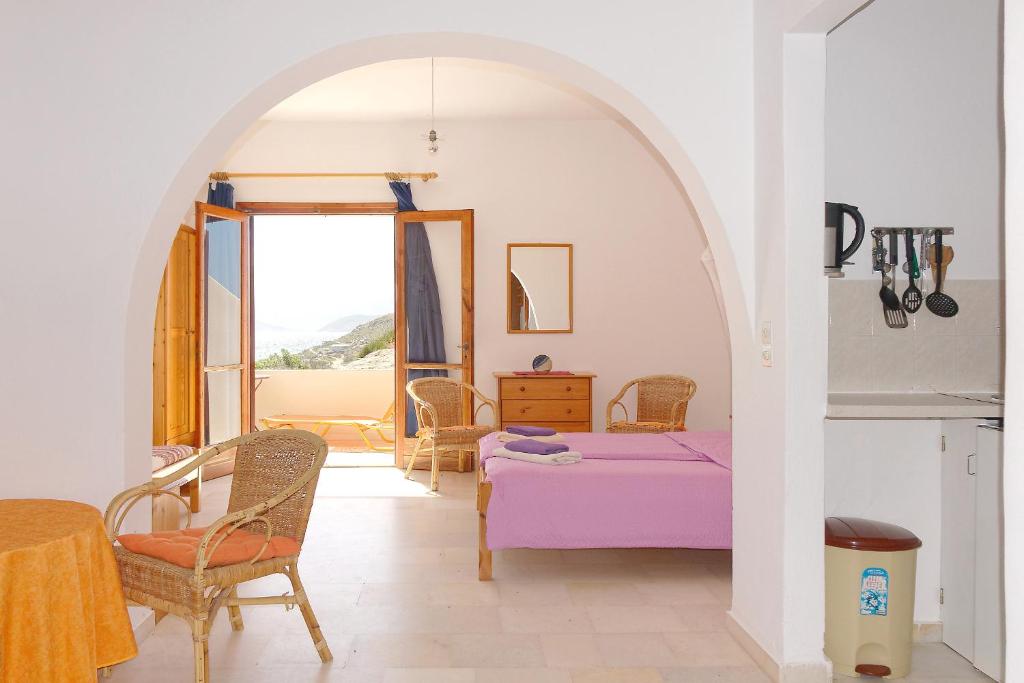 Cette chambre comprend un lit, une table et des chaises. dans l'établissement Askella, à Ágios Prokópios