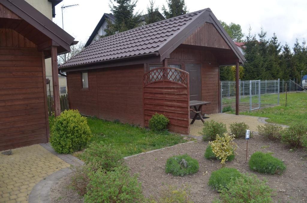uma pequena casa com uma porta de madeira num quintal em Domki Sara em Władysławowo
