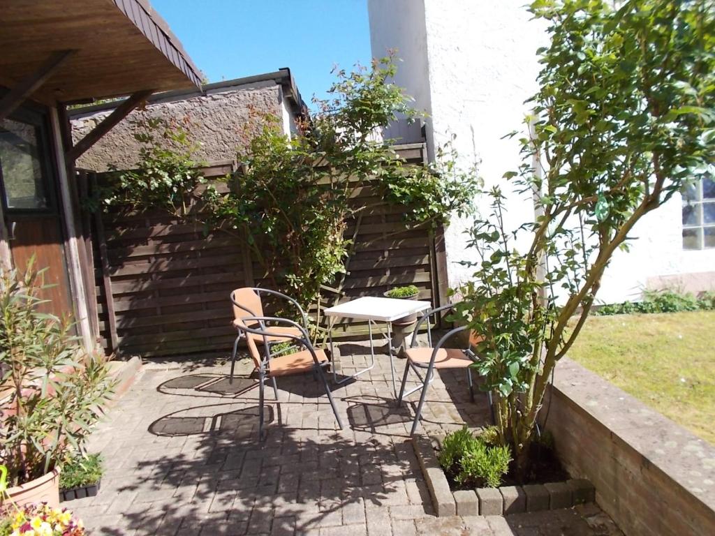 a patio with a table and chairs in a garden at Ferienwohnung Janne in Fürstenberg