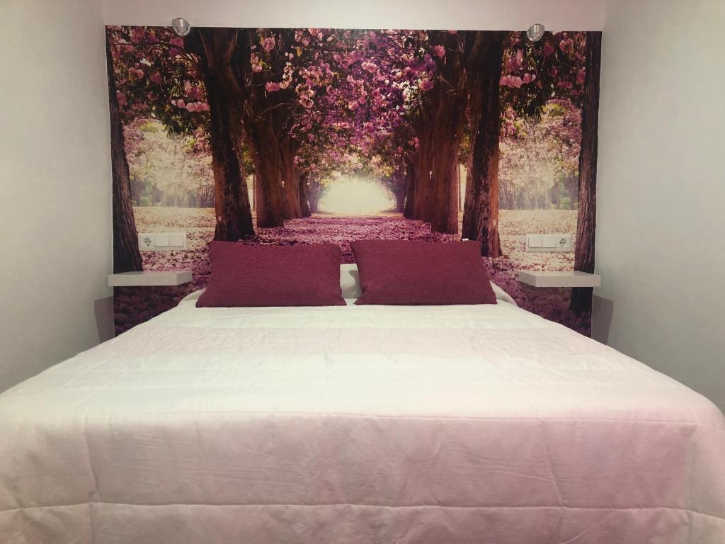 a bedroom with a large bed with flowers on the wall at Apartamento de Lola in Setenil