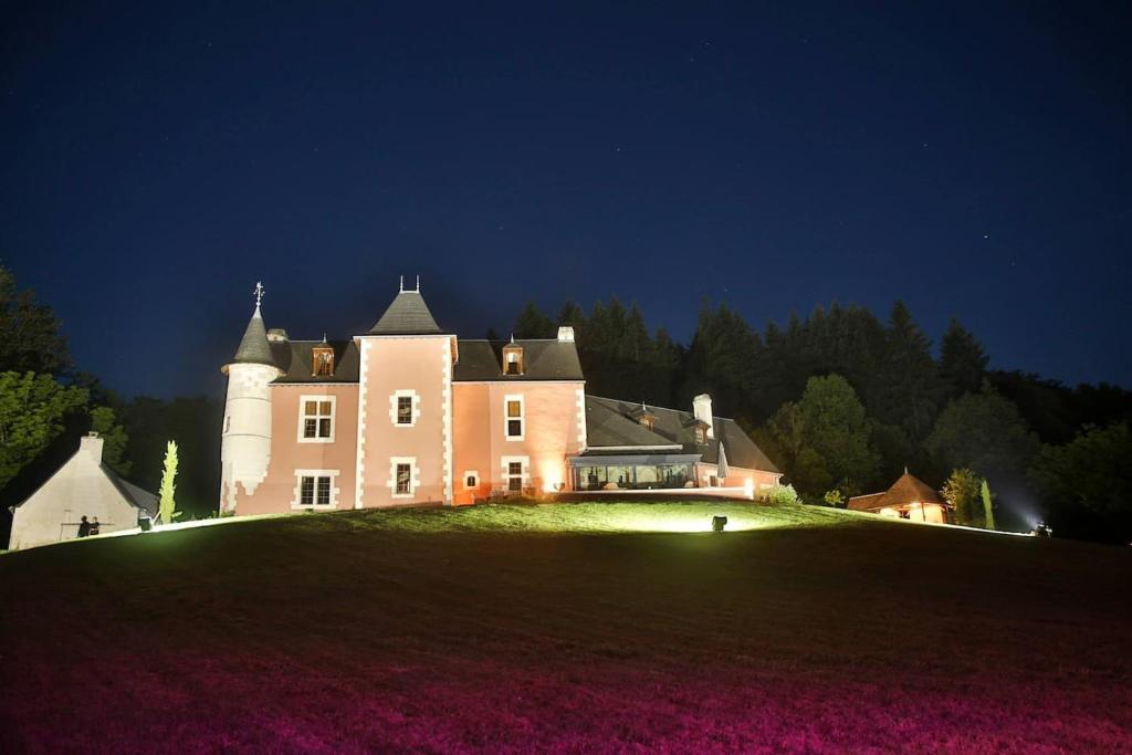 ein großes Haus auf einem grasbewachsenen Hügel in der Nacht in der Unterkunft Chateau de Vau Rozet in Continvoir