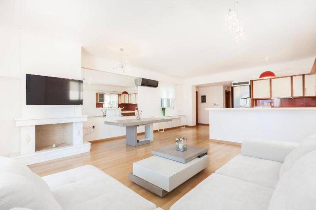 a living room with a white couch and a table at New Luxury Apartment in Glyfada with pool in Athens