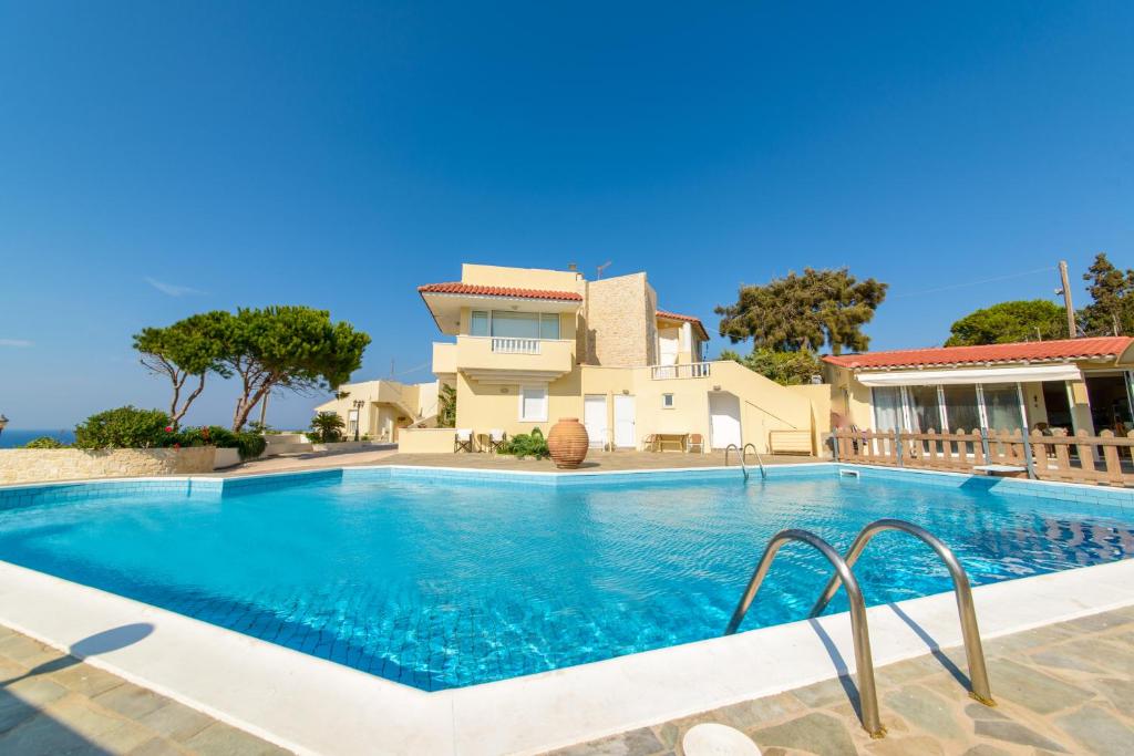 une villa avec une piscine en face d'une maison dans l'établissement Villa Lygaria, à Ligaria