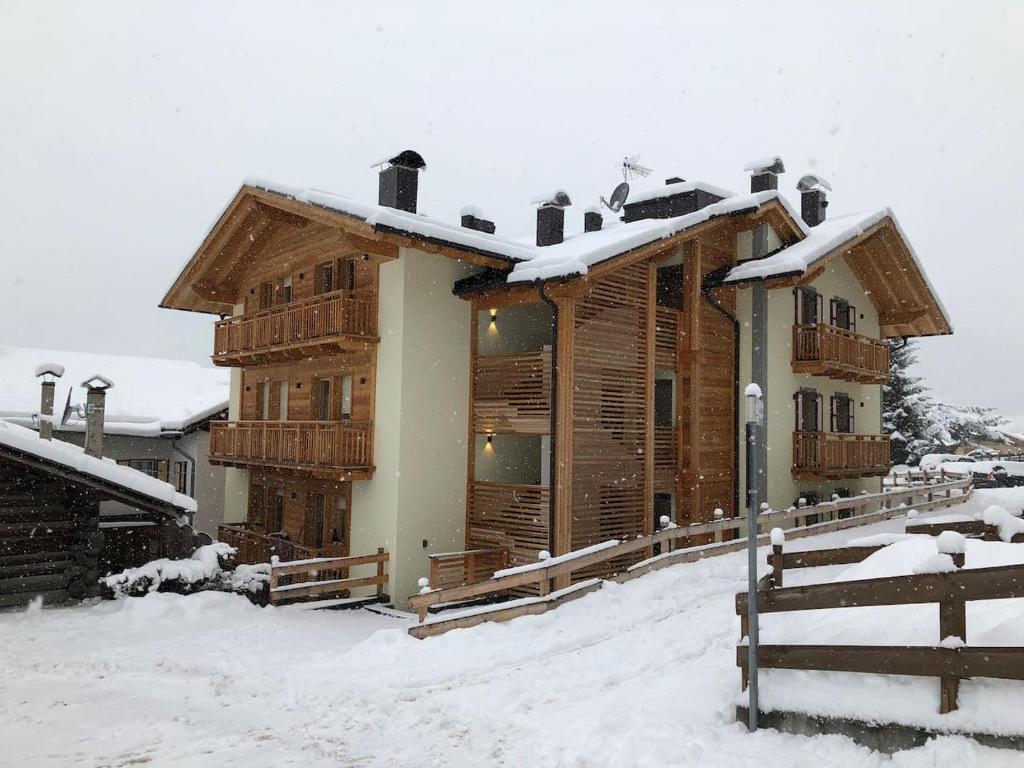 a large wooden house with snow on the roof at Casa Chris in Pozza di Fassa
