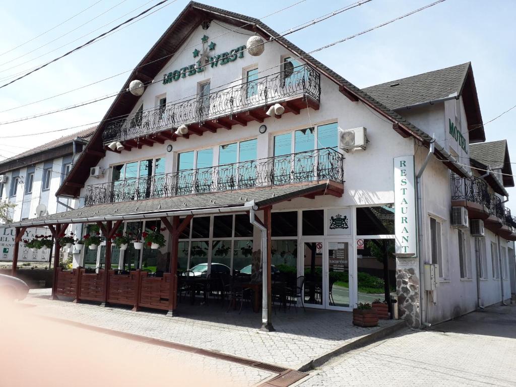 Un edificio con un balcón en el lateral. en Westmotelrestaurant, en Pădurea Urziceni
