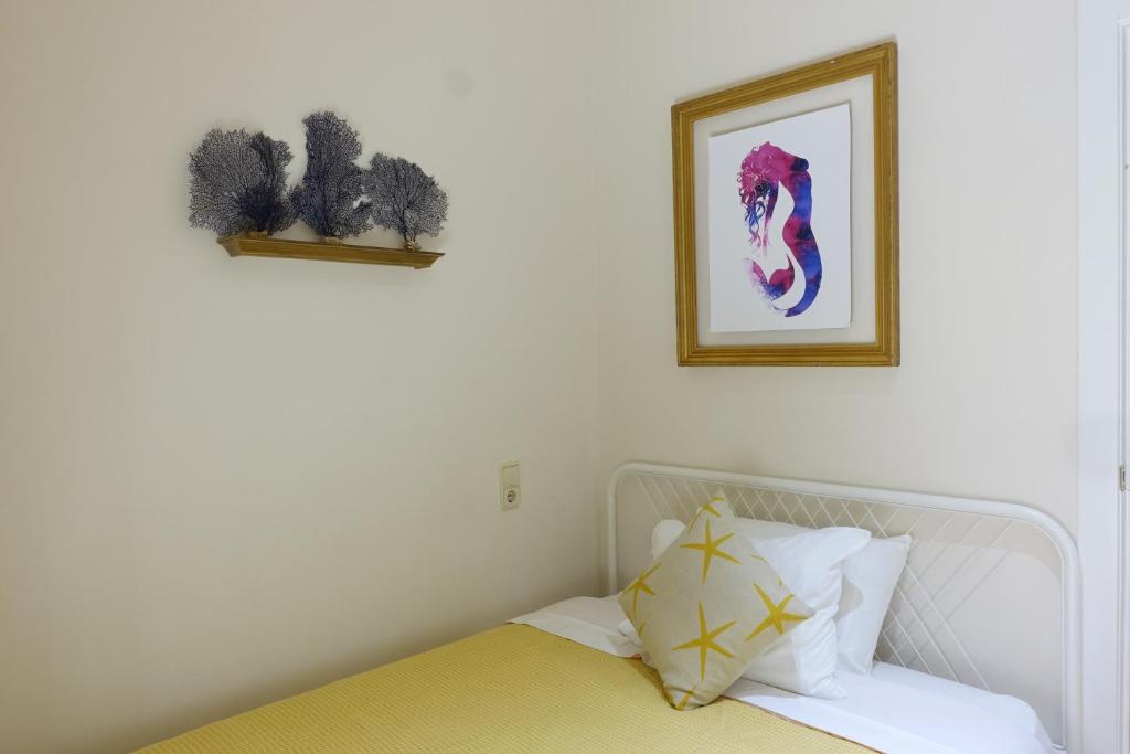 バレンシアにあるBest XL Valencia Beach Flatのベッドルーム1室(ベッド1台付)が備わります。壁に絵が飾られています。