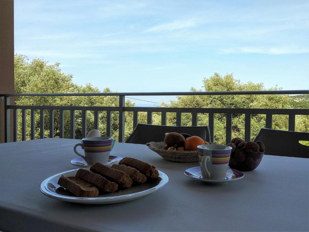 een tafel met twee borden eten en kopjes koffie bij Majia 2 bedroom apartment in Gerani