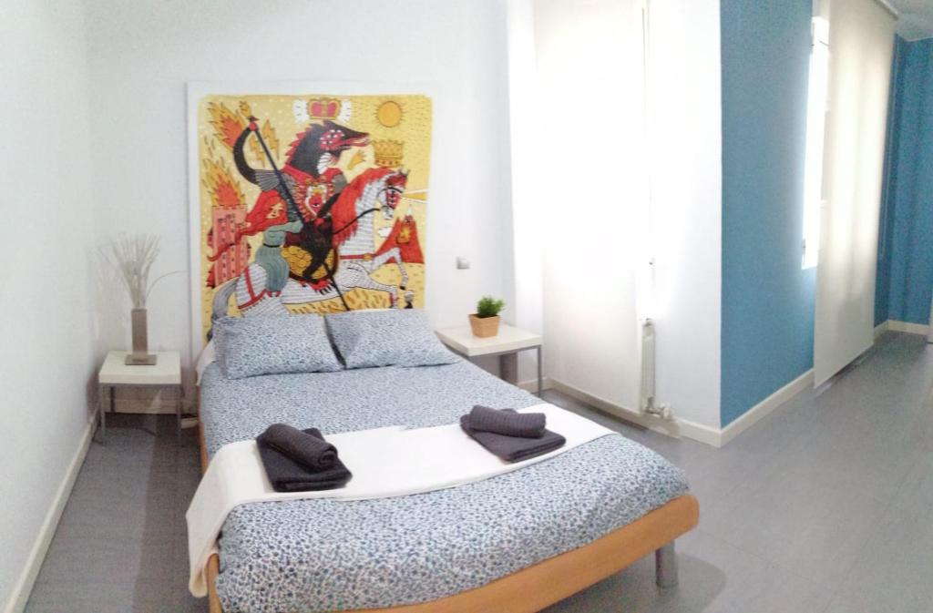 a bedroom with two beds and a painting on the wall at Dos Torres Puerta del Carmen - Moderno y Espacioso en el Centro in Zaragoza