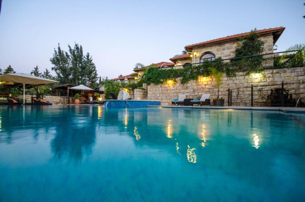 une grande piscine en face d'un bâtiment dans l'établissement Renaissance Estate, à Rosh Pinna