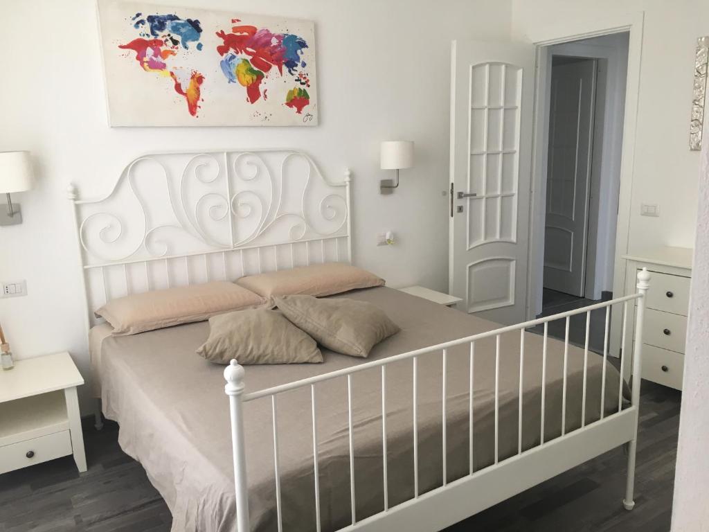 a bedroom with a white bed with a white crib at VINILE in Cagliari