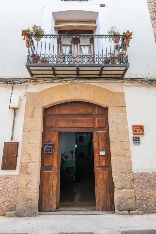 a building with a balcony over a wooden door at CASA MICOLAU in Beceite