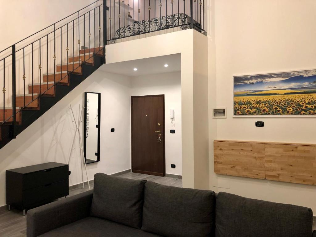 ein Wohnzimmer mit einem Sofa und einer Treppe in der Unterkunft Corte Del Carmine in Bari
