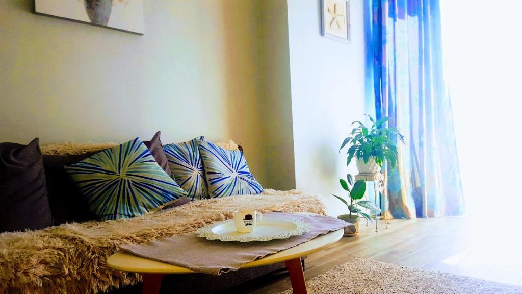 una sala de estar con sofá y mesa con un plato. en Here comes the sun, en Batumi