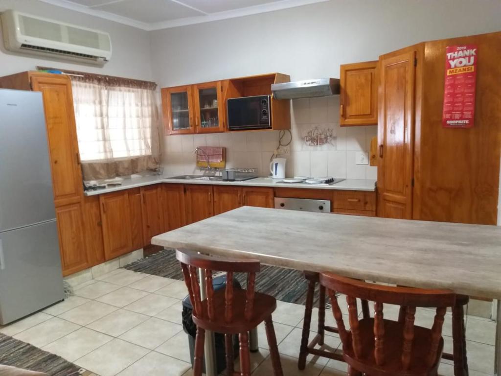 a kitchen with a table and some wooden cabinets at Unit 19 Villa Mia Apartment in St Lucia