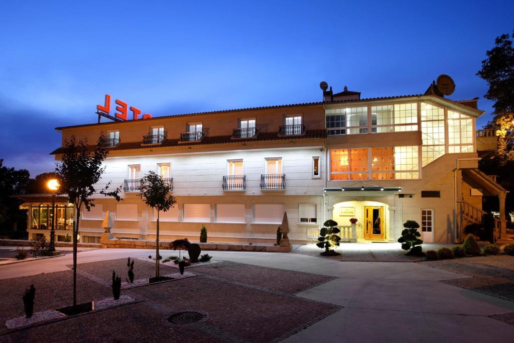 a large building with a lit up facade at night at Hotel A Queimada in Parada