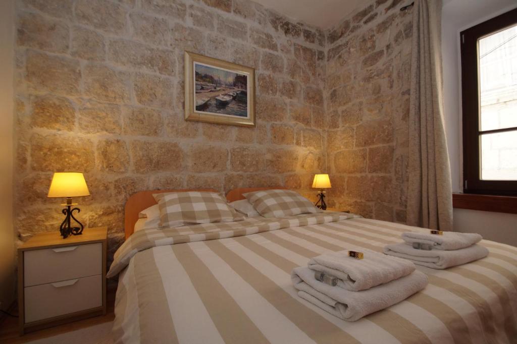 a bedroom with a bed with towels on it at Apartments Sunny Town in Korčula