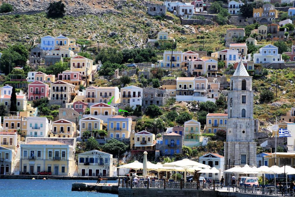 a group of houses on a hill next to the water at Pitini Nikos house in Symi