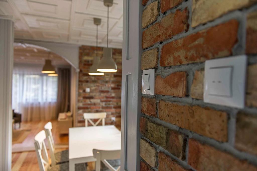 a brick wall with a table and chairs in a room at RETRO HOUSE in Sztutowo