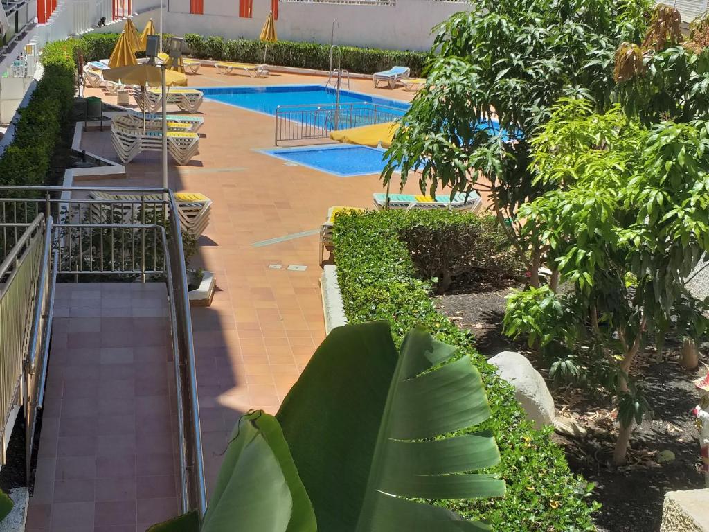 vista sulla piscina dalla parte superiore di un edificio di Playa del Ingles Cosy Apartment a Maspalomas