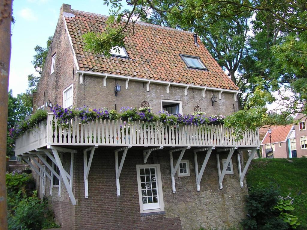 uma casa com uma varanda com flores em De Vier Kroonen em Enkhuizen