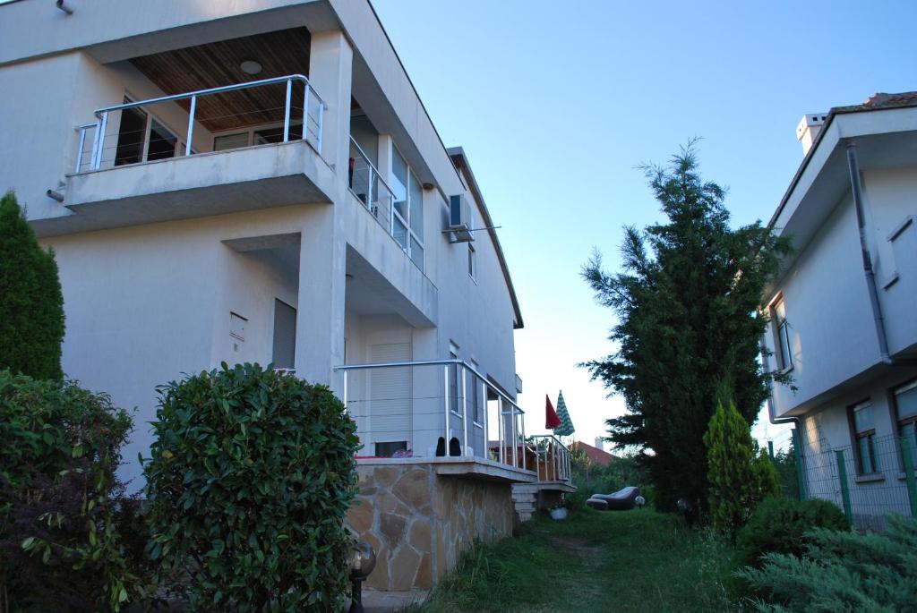 - un bâtiment blanc avec un balcon sur le côté dans l'établissement Villa California, à Sinemorets