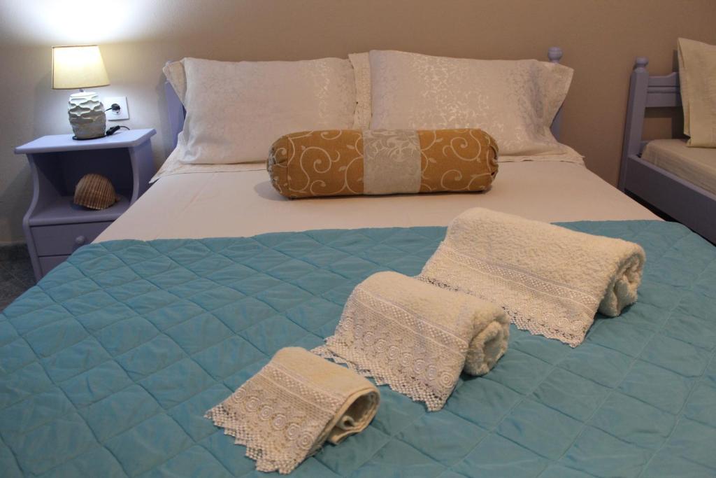 a bed with two blankets and pillows on it at Vakis Apartments in Romanón